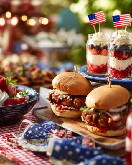 Festive Summer Picnic Table With 4th Of July Food Grilled Hot Dogs BBQ Chicken Burgers Fruit Skewers Flag Cake Berry Lemonade Checked Table Cloth